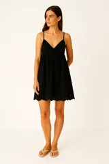 Vestido corto negro con breteles finos ajustables, escote profundo en V con borde festoneado y falda con detalle de bordado calado (broderie) en el ruedo.