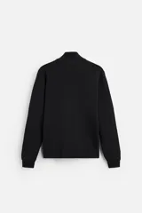 Jersey negro de punto de algodón, corte recto, cuello perkins con cremallera metálica y mangas largas terminadas en rib.