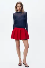 Falda mini roja de punto con cintura elástica y corte evasé.