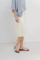 Bermuda color crema de tiro medio con corte recto y largo por la rodilla. Diseño amplio tipo culotte corto, con dobladillo ancho en el ruedo. Presenta bolsillos delanteros y traseros funcionales. Confeccionada en denim suave y cómodo.