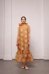 Vestido largo y amplio con cuello alto y mangas cortas abullonadas. Diseño a rayas verticales en tonos dorado y gris. Incluye viso liso al tono.