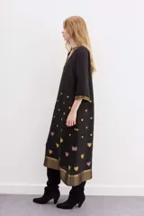 Vestido largo negro de viscosa con bordados de corazones en el cuerpo y ruedo con jacquard de lurex.
