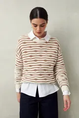 Sweater de punto color beige con rayas horizontales marrones en relieve, cuello redondo y mangas largas.