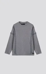 Sweater de manga larga color gris jaspeado, con cuello redondo. Presenta costuras externas decorativas y marcadas en los laterales del cuerpo y en la unión de las mangas, dándole un aspecto técnico o deconstruido.