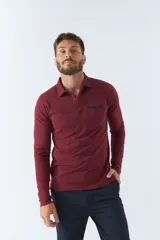 Polo de manga larga negra con cuello clásico, tapeta de dos botones y bolsillo de parche en el pecho con ribete blanco. Logo de la marca bordado en blanco sobre el bolsillo.