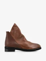 Botín de cuero marrón con diseño asimétrico y líneas modernas.