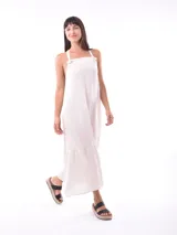 Vestido largo color crudo, con breteles finos y volados en el ruedo.