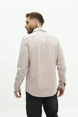 Camisa de manga larga color beige, de corte clásico y fit regular.