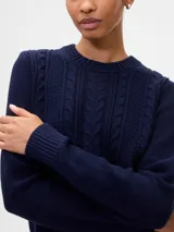 Buzo de algodón negro con cuello redondo, manga larga y tejido de punto con trenzas y calados en el frente.