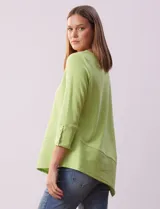 Blusa verde en tejido acanalado, marca Ruby Rd. Largo de mangas ¾ con abertura y botones. Terminación de ruedo asimétrico.