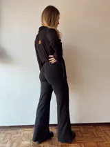 Pantalón negro acampanado de tejido de punto acanalado con cintura elástica.