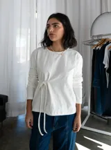 Remera blanca de manga larga con lazo en la cintura.