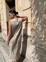 Vestido midi color beige, de corte recto y sin mangas, con estampado de líneas blancas.