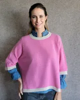 Sweater rosa de lana lambswool con cuello y puños en color crema.