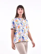 Remera blanca con estampado de hojas en tonos celeste, azul, naranja y rosa.
