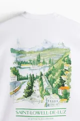 Remera blanca de algodón pesado con cuello redondo y estampado pequeño en el pecho. Corte oversized con hombros caídos y bajo recto.