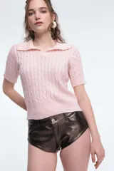 Sweater de punto rosado con cuello polo y mangas cortas.