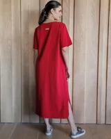 Vestido midi negro con cuello redondo y mangas cortas. Presenta dos bolsillos cuadrados en el pecho y ribetes blancos en cuello, mangas, bolsillos y ruedo.