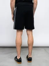 Bermuda deportiva azul marino de piqué con cintura elástica ajustable con cordón, bolsillos laterales y logo Umbro bordado en blanco.