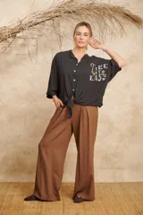 Camisa negra de lino con botones, mangas 3/4 y detalle de lentejuelas con la frase "Take it easy" en el frente.