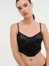 Corset blanco de satén con tirantes finos regulables y ballenas verticales.