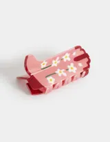 Broche para el pelo de acrílico color rosa con diseño de flores blancas.