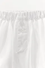 Shorts de popelín blanco con cintura elástica y botones decorativos.