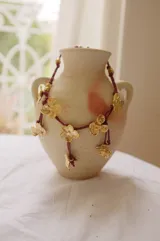 Collar corto con cordón de algodón color menta y flores de bronce.