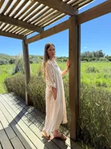 Vestido camisero amplio y largo de lino color azul, con botones de nácar, cuello camisero y bolsillos laterales.