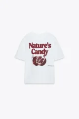 Camiseta blanca de algodón con cuello redondo y mangas cortas. Estampado frontal con la frase "Nature's Candy" y una granada.
