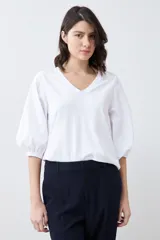 Remera blanca con escote en V y mangas balloon 3/4.