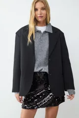 Minifalda negra de punto con lentejuelas plateadas, de calce ajustado y confección en tejido de punto tipo twill.