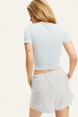 Remera cropped celeste con escote amplio en U y mangas cortas. De punto acanalado fino de algodón y ajuste entallado.