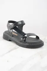 Sandalias negras de cuero con plataforma y tiras ajustables.