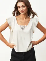 Blusa negra de satén con escote en V y detalle de encaje en el escote.
