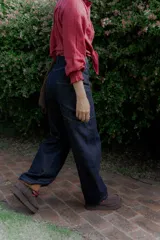 Jean wide leg color marrón, con corte recto y amplio, y costuras protagonistas que crean un diseño geométrico en las piernas.