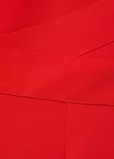 Mono largo de poliéster rojo, con escote de pico, tirantes anchos y detalle cruzado en la cintura. Cierre de cremallera invisible en la parte posterior.
