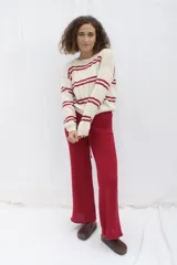 Conjunto de punto color borgoña, compuesto por un cárdigan corto con mangas acampanadas y lazo de ajuste frontal, y un pantalón de corte palazzo con cintura alta y cordón de ajuste.