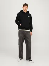 Hoodie negro con capucha y manga larga, de fit holgado y tejido loop back.