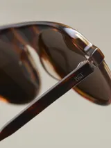 Lentes de sol con montura redonda color carey y lentes marrones.