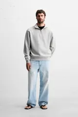 Sudadera color crema de corte recto, con cuello polo y cierre de cremallera metálica.