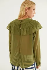 Blusa de gasa azul marino traslúcida con volados en los hombros y mangas largas abullonadas.
