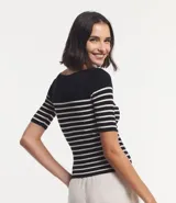 Blusa de punto con textura acanalada, escote barco y mangas 3/4. Diseño a rayas horizontales blancas y negras.