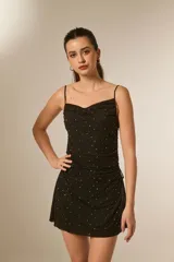 Vestido corto negro de poliéster, ajustado al cuerpo, con escote fruncido tipo buche y tirantes finos. El tejido presenta un estampado de puntos brillantes o strass.