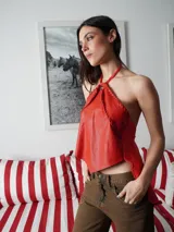 Top dorado de cuero con espalda de lino, corte irregular y cuello halter con detalle de un caballito.