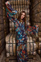 Camisa de tul elastizado con estampado paisley en tonos azul, naranja y marrón. Tiene corte clásico, cuello solapa, mangas largas acampanadas y cierre abotonado.