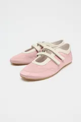 Zapato tipo bailarina deportiva color rosa con efecto satinado, puntera redondeada y doble tira con ajuste adhesivo.