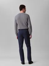 Pantalón chino de corte slim color azul marino, confeccionado en algodón y elastano. Presenta cierre con cremallera y botón, diseño clásico de cuatro bolsillos y logo de Calvin Klein bordado en la parte posterior.