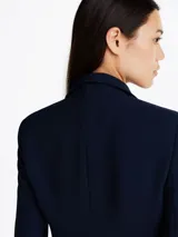 Americana azul marino de crepé con corte slim, solapas con muescas, botonadura sencilla con cierre de botón, dos bolsillos de ojal en la cintura, detalles distintivos de Tommy Hilfiger y logo esmaltado de Tommy Hilfiger en el puño.