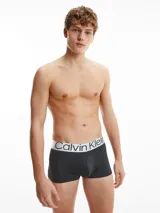 Pack de tres bóxers negros Calvin Klein de corte low rise, con cinturilla elástica gris con el logo de la marca en blanco.